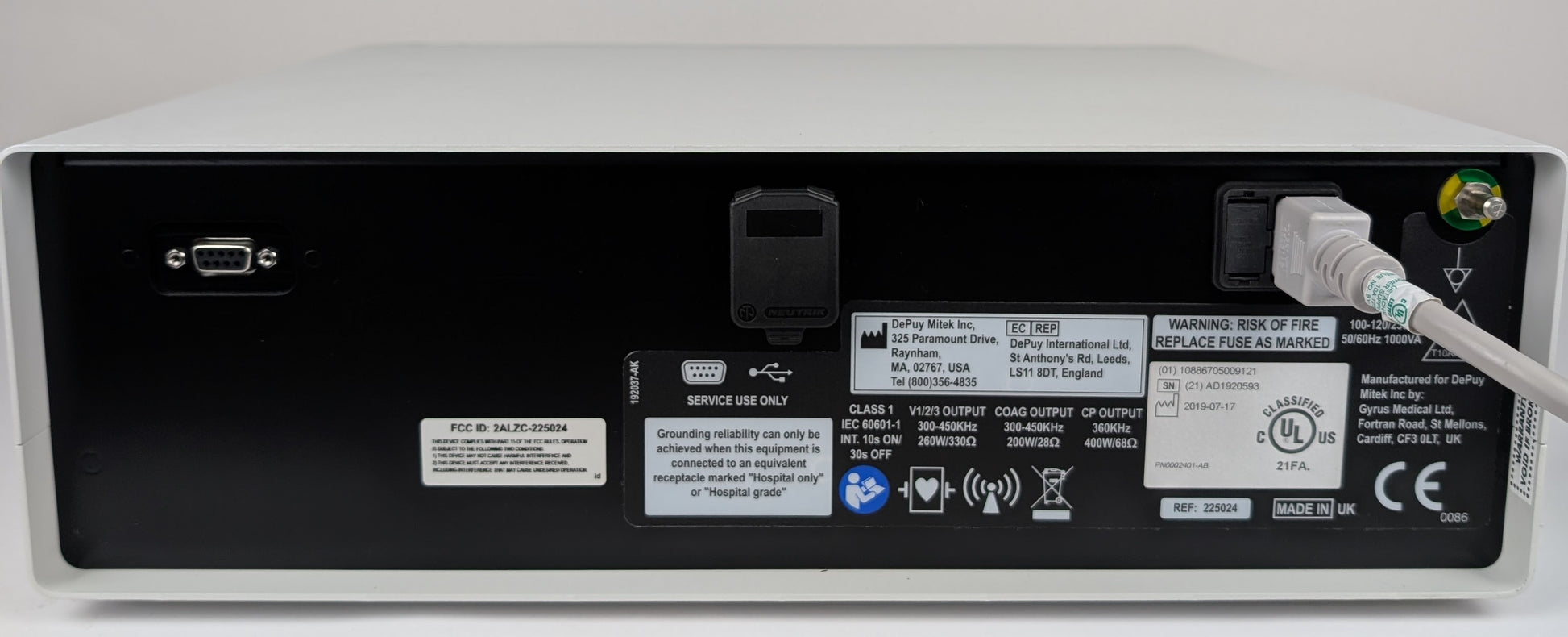 Back view of a medical device with various labels and ports.