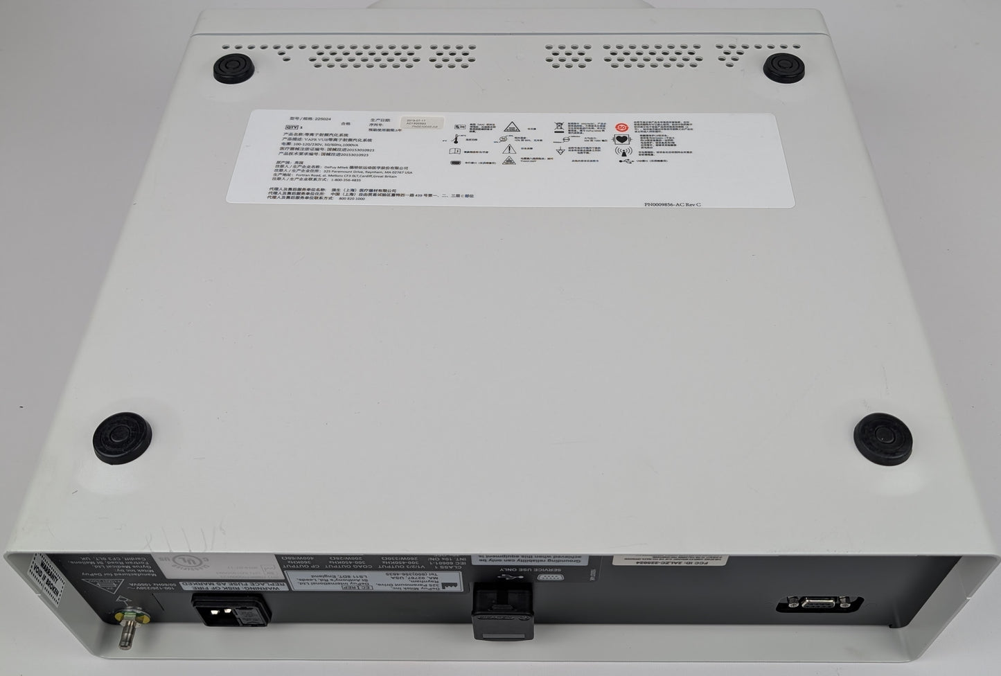 Back view of a electronic device with labels and ports on a gray background