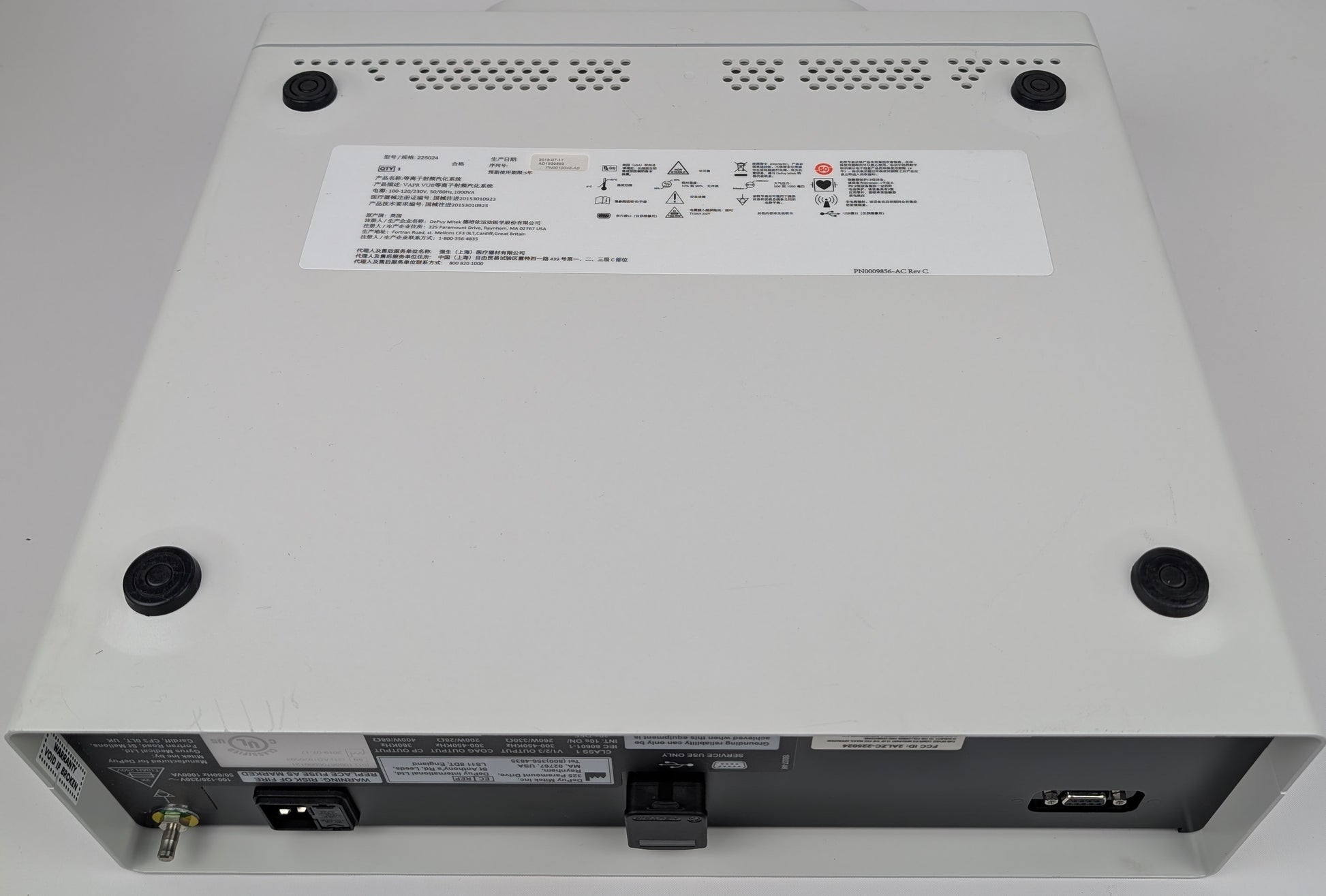 Back view of a electronic device with labels and ports on a gray background