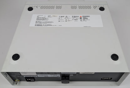 Back view of a electronic device with labels and ports on a gray background